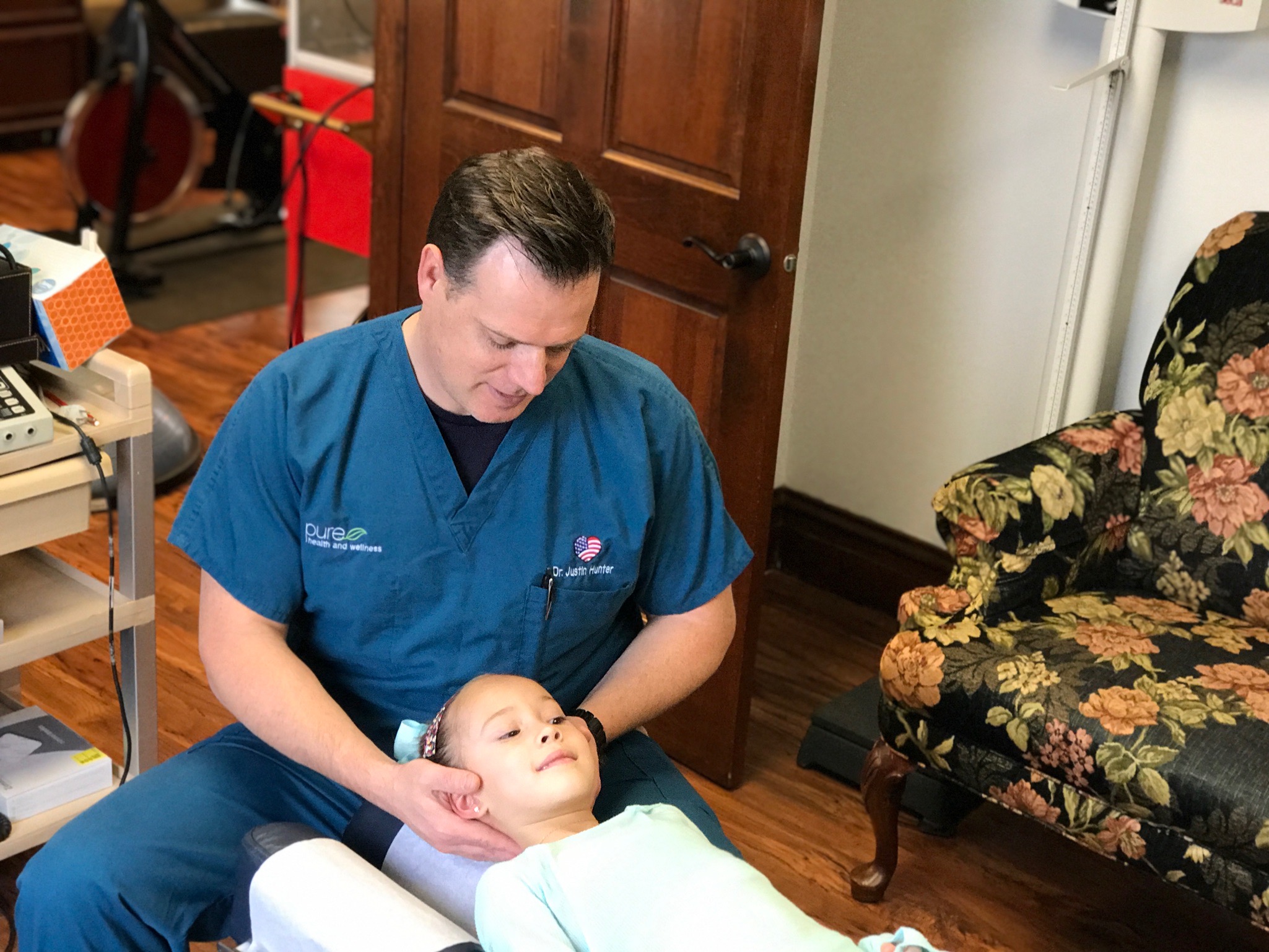 Dr. Hunter supporting a young patient's head and neck during an adjustment