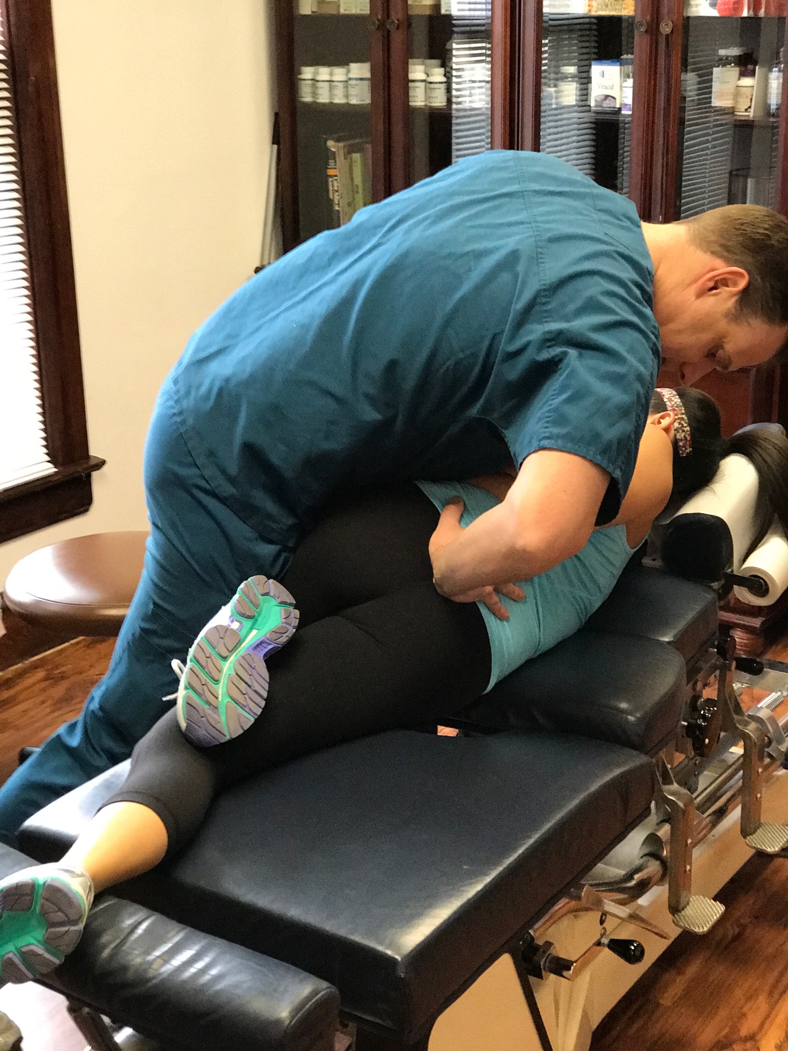 Dr. Hunter performing a side-posture lower back adjustment on a patient