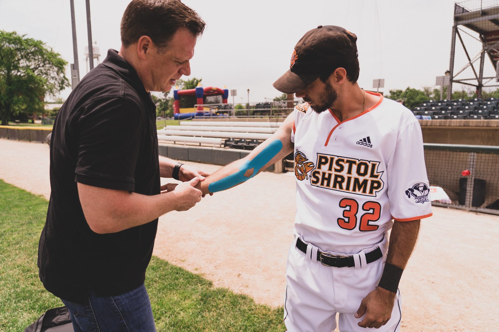 Dr. Justin Hunter applying kinesiology tape to an athlete